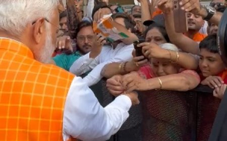 अहमदाबाद में मतदान केंद्र के बाहर भारी भीड़ के बीच बुजुर्ग महिला ने पीएम मोदी को बांधी राखी